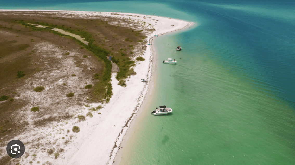 Aerial view of a sandbar near Clearwater Beach with boats anchored in turquoise water.