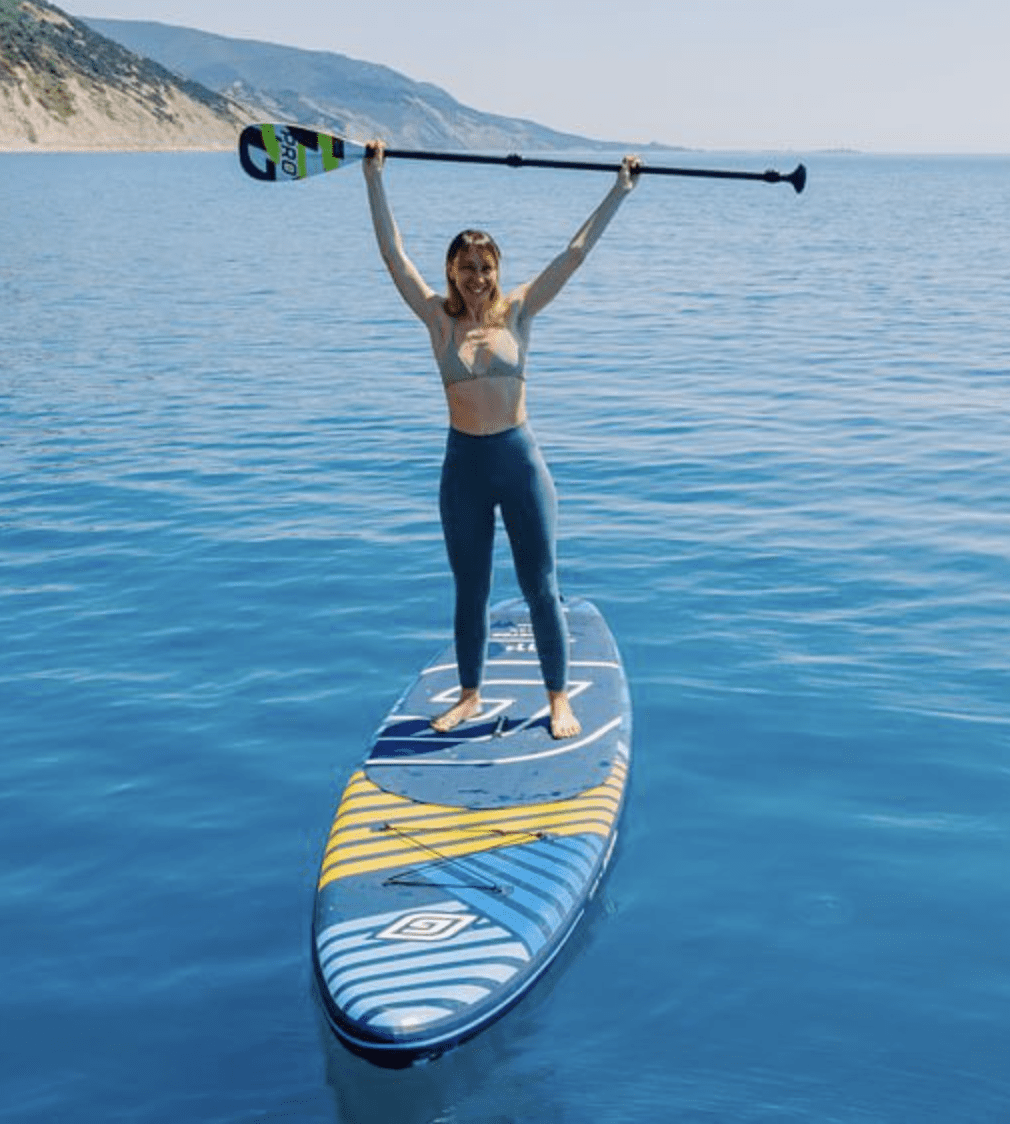 Woman standing on a paddleboard over crystal-clear blue water in Clearwater Beach