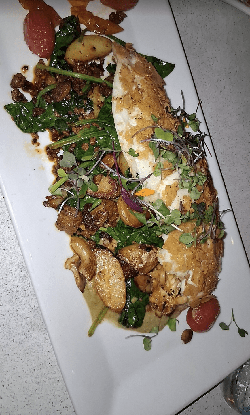 Pan-seared fish fillet with sautéed potatoes and microgreens at a Clearwater Beach restaurant