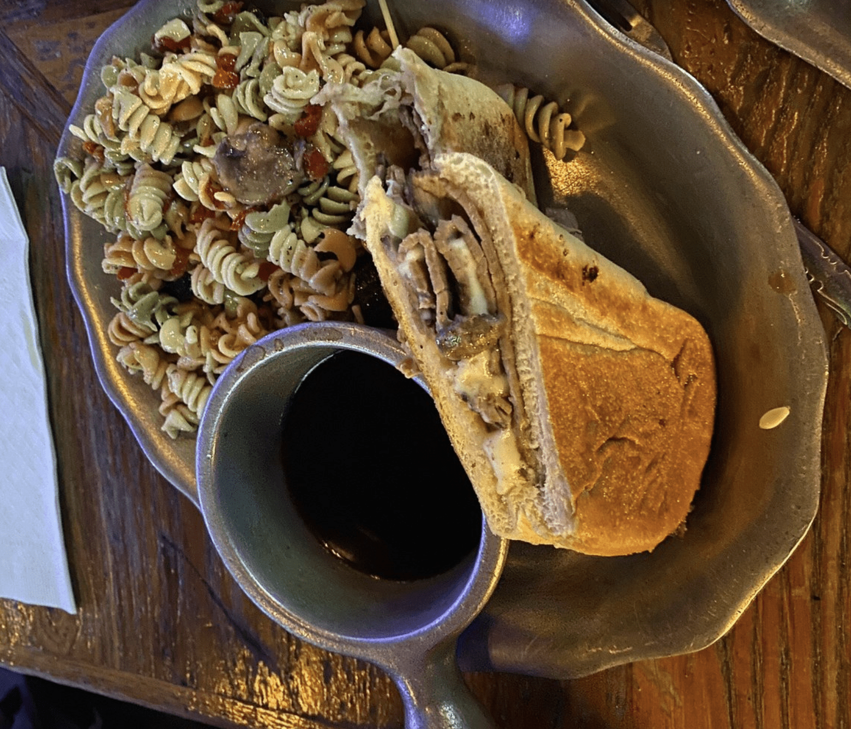 Roast beef sandwich with au jus dip and tri-color pasta salad served in Clearwater Beach.