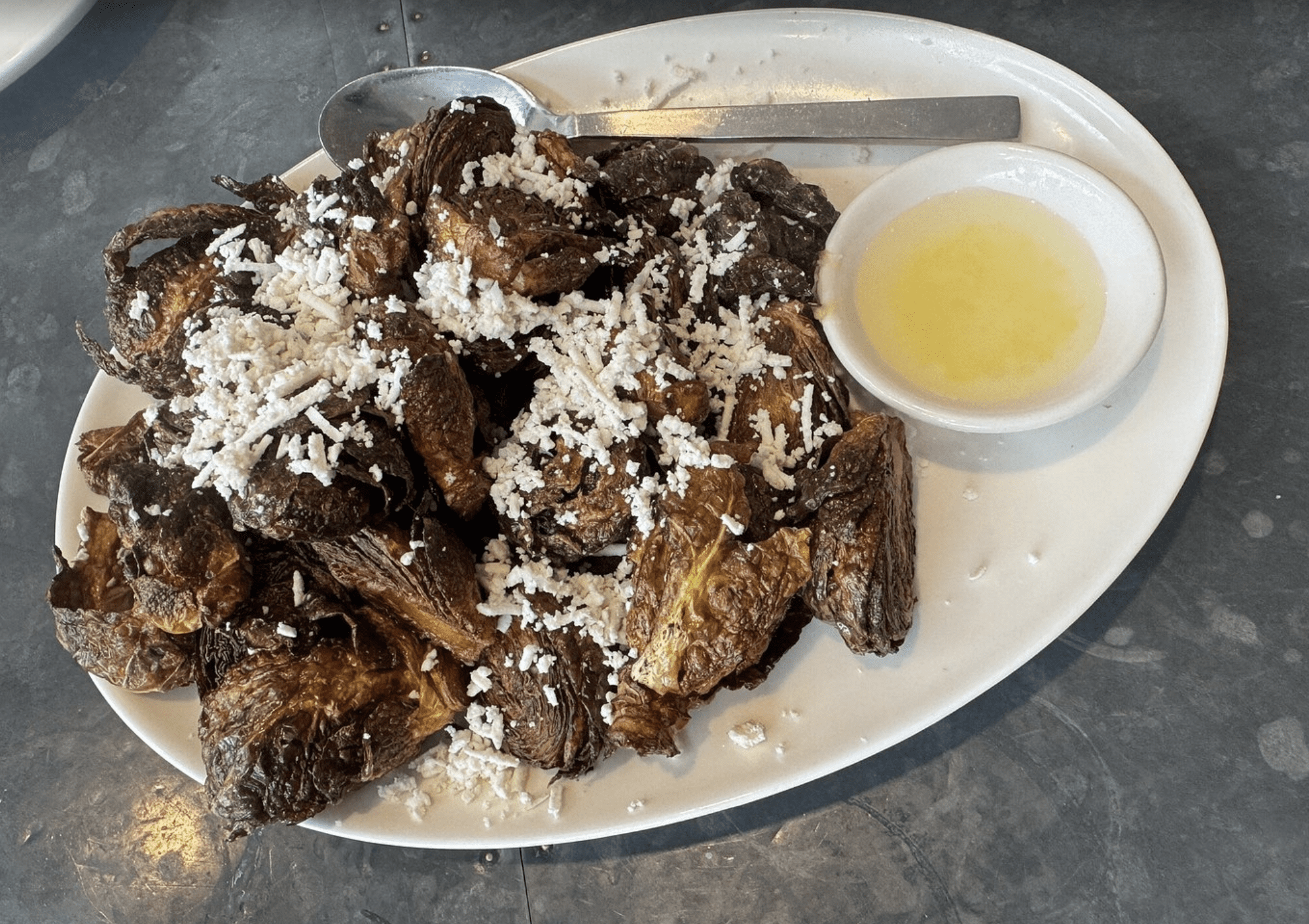 Crispy roasted Brussels sprouts topped with cheese and lemon butter sauce at a Clearwater Beach restaurant.