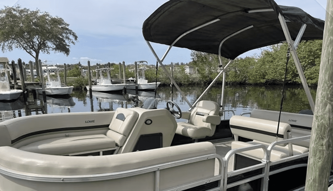 Pontoon boat docked at a Clearwater Beach marina ready for rental.