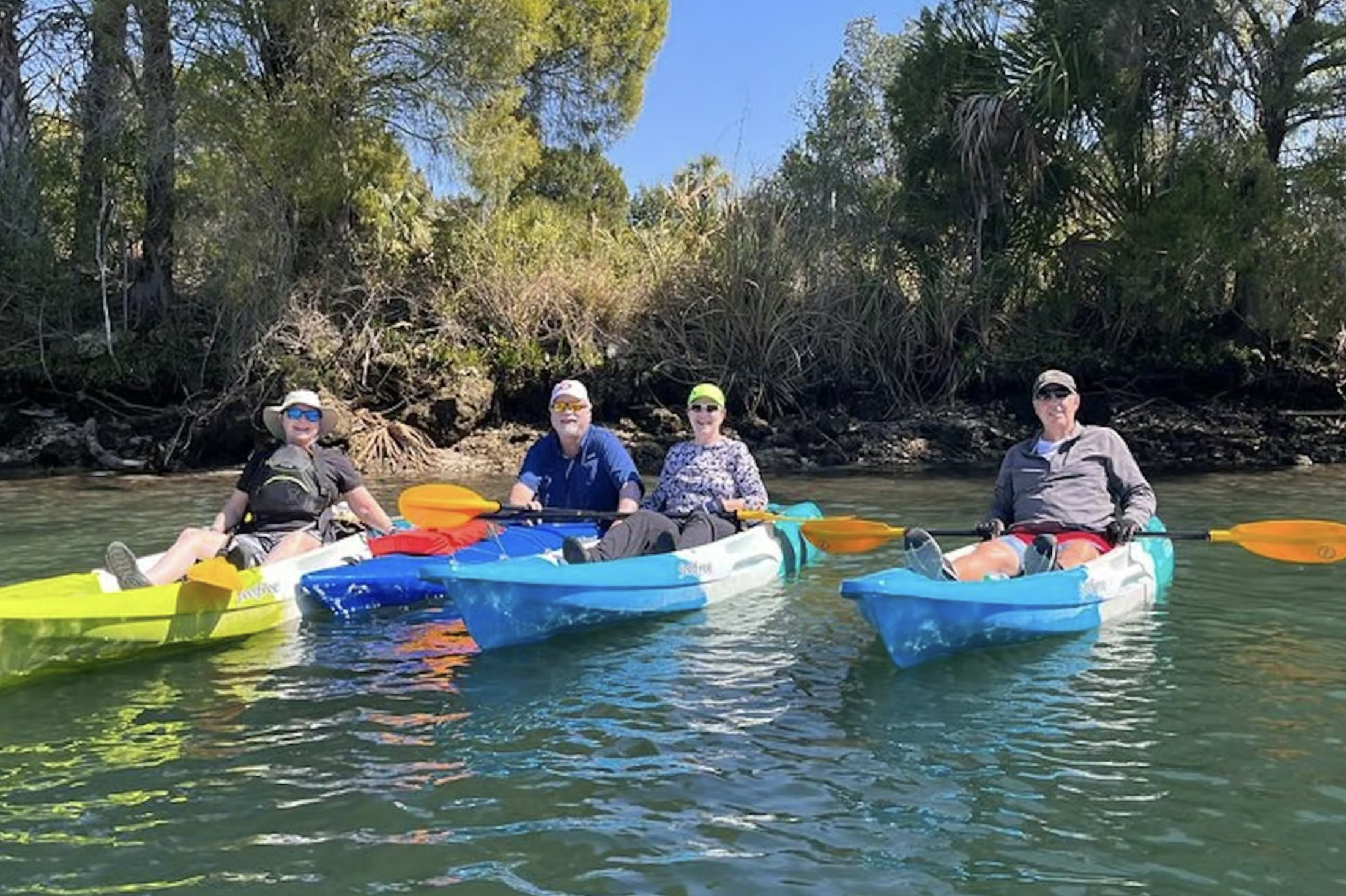 Group kayaking on calm waters surrounded by trees in Crystal River.