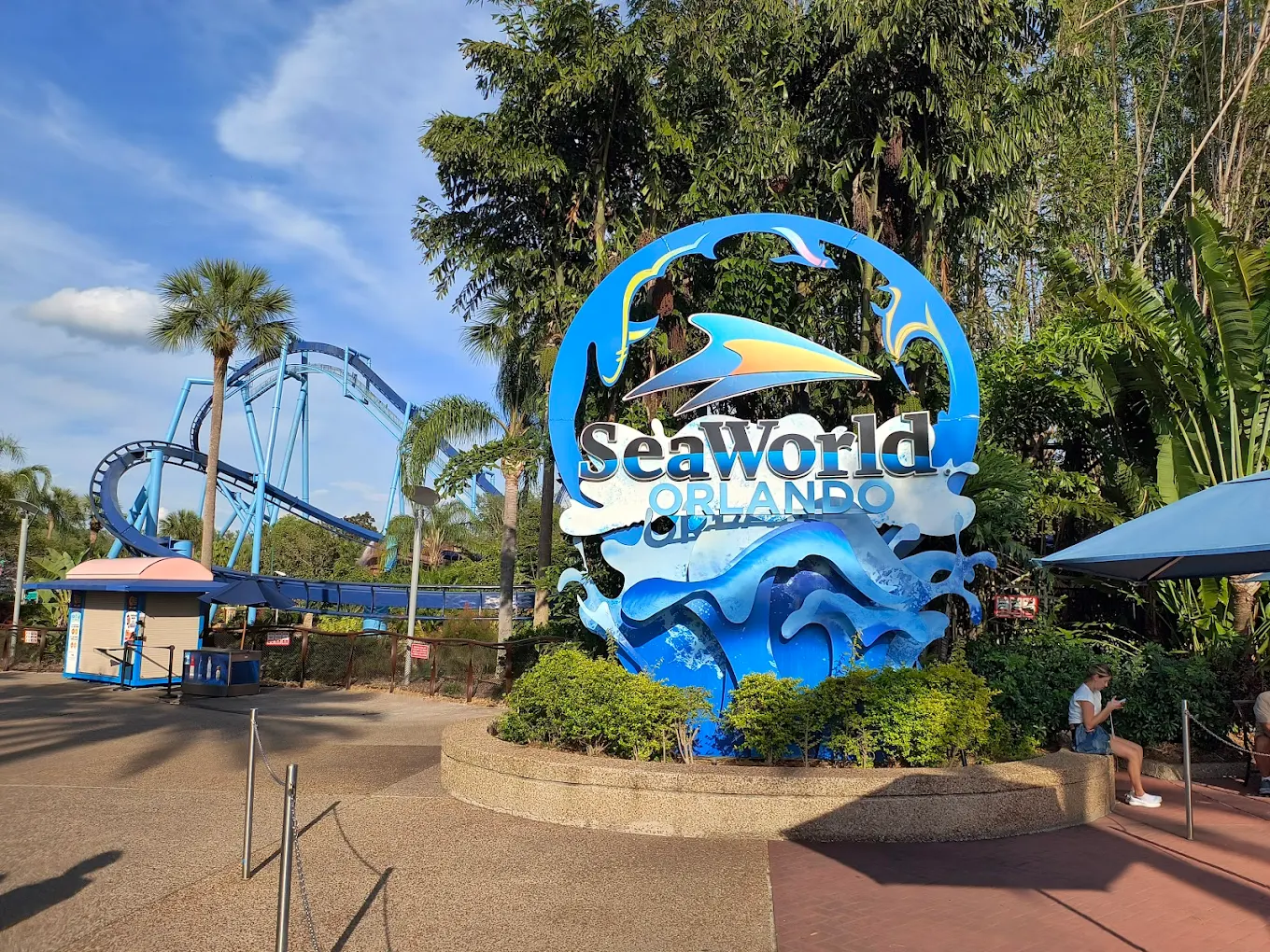 SeaWorld Orlando entrance sign with blue roller coaster in the background.