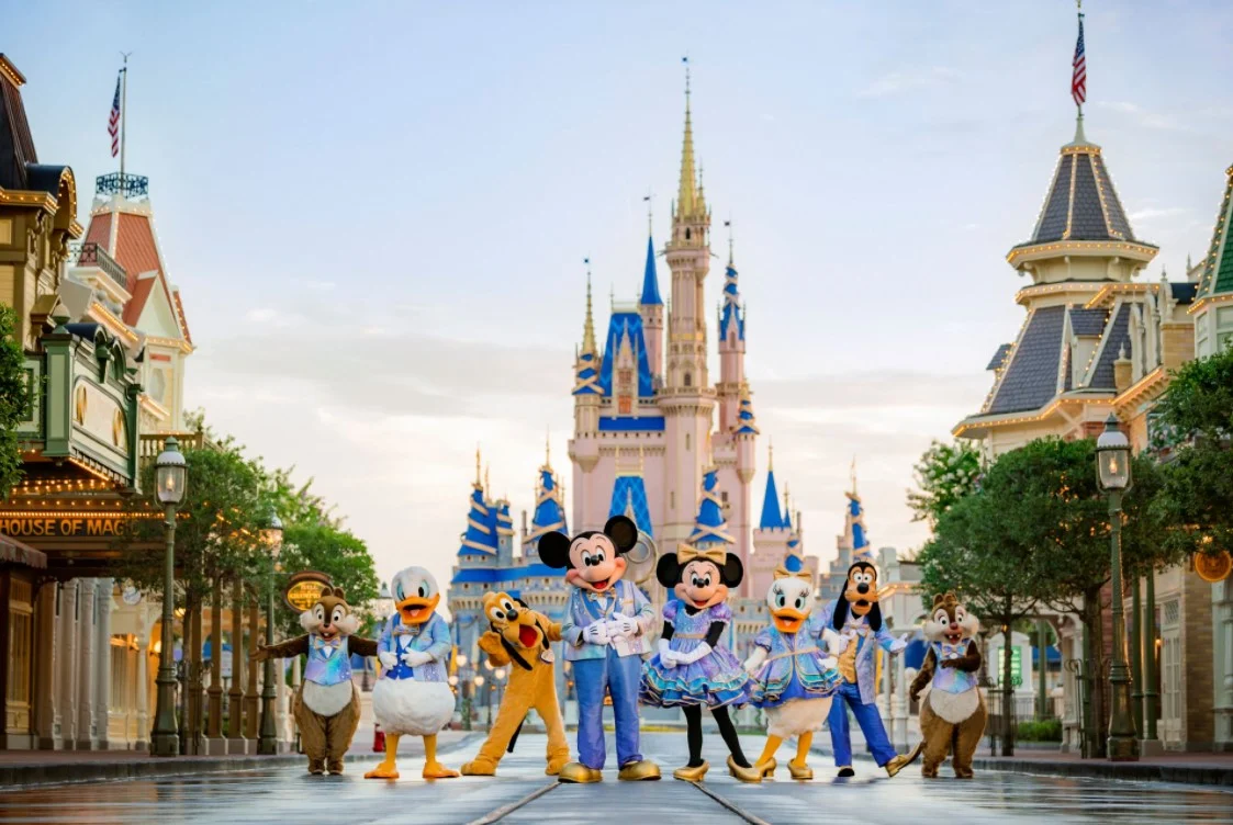 Disney characters posing on Main Street USA in front of Cinderella Castle at Magic Kingdom.